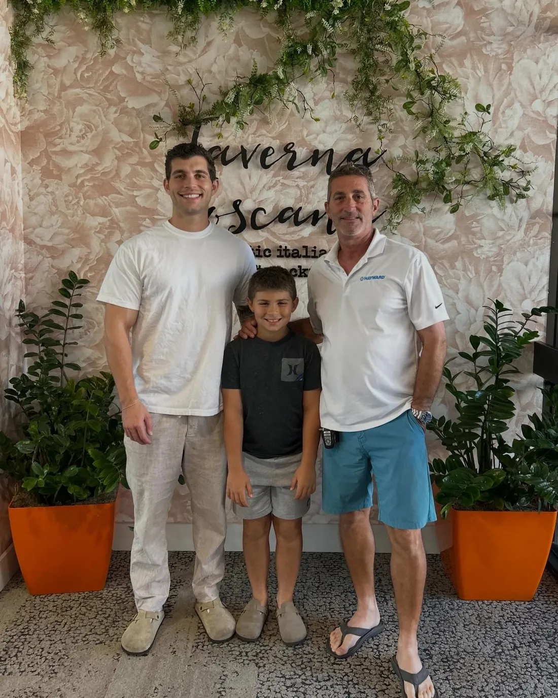 Jake, his little brother, and their dad standing together and smiling
