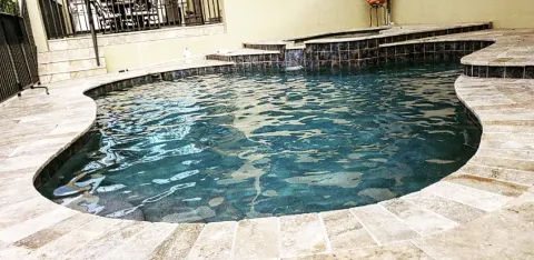 Freeform pool with travertine deck